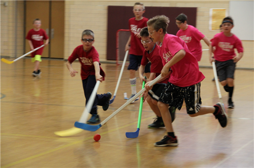 Floor hockey players scramble for the puck 